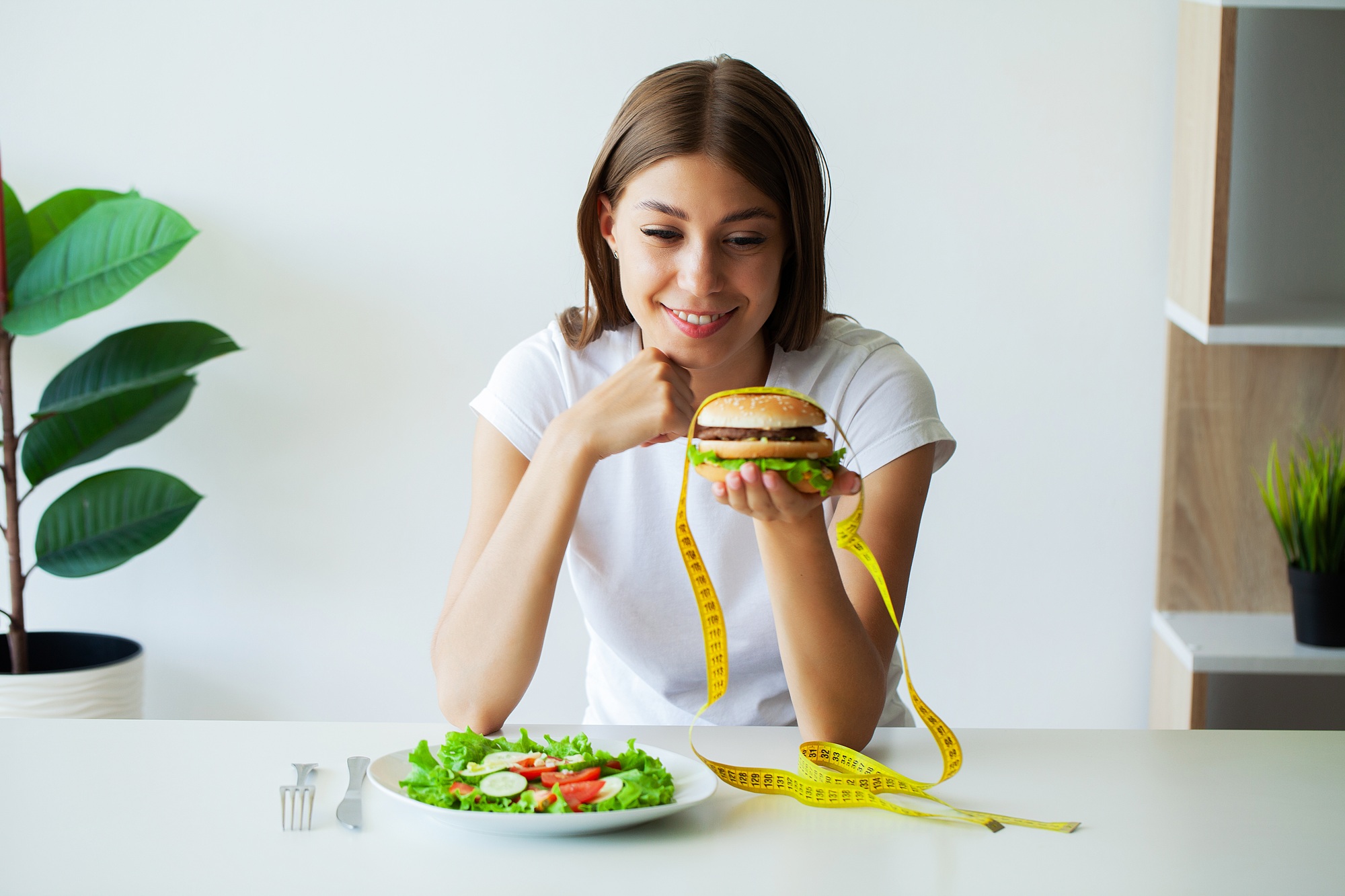 Young woman on a diet, eats only salad and tries to lose weight