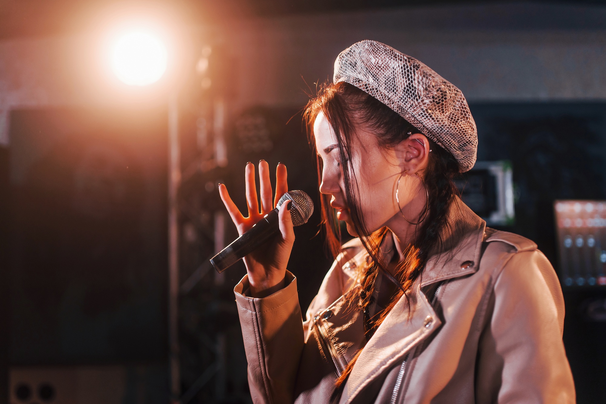 Young beautiful female singer rehearsing in a recording studio