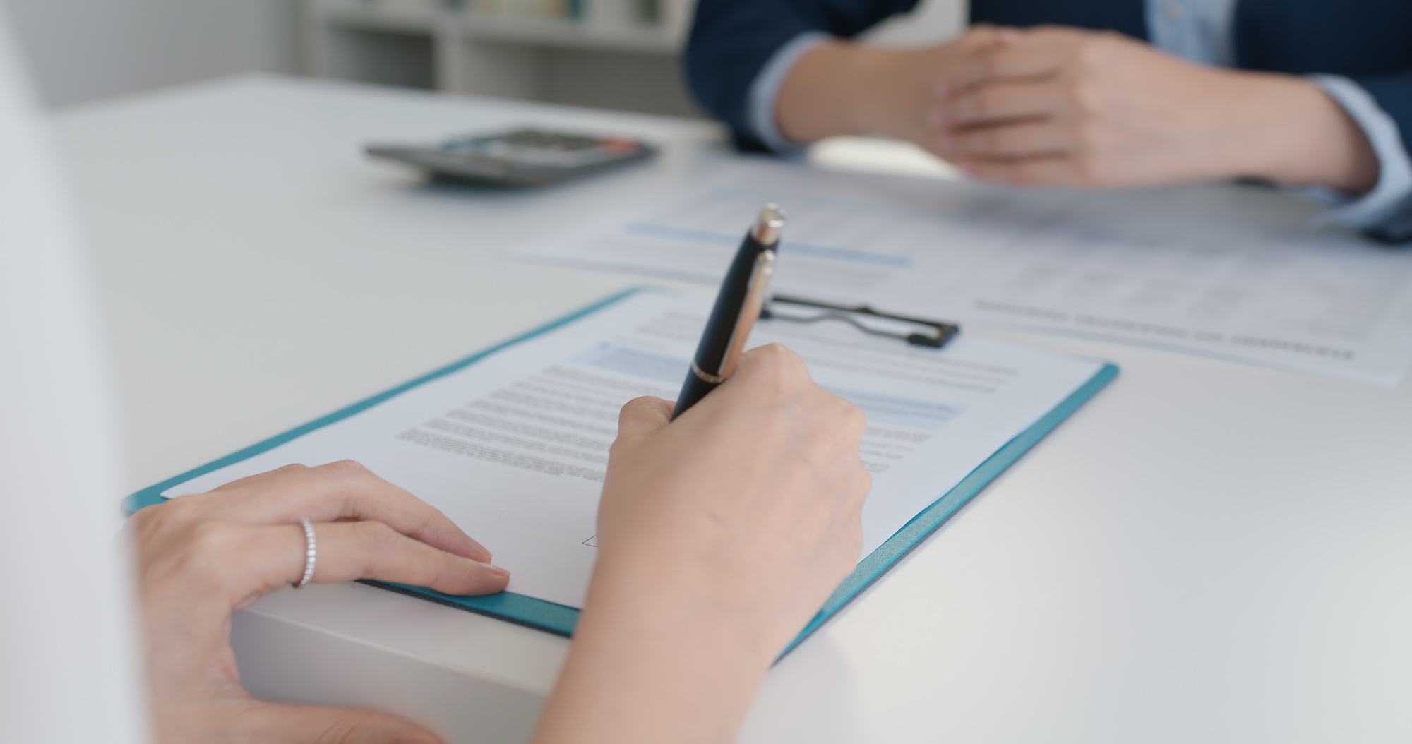 Close-up hand asia people woman fill rent loan form write legal debt letter at lawyer home office.